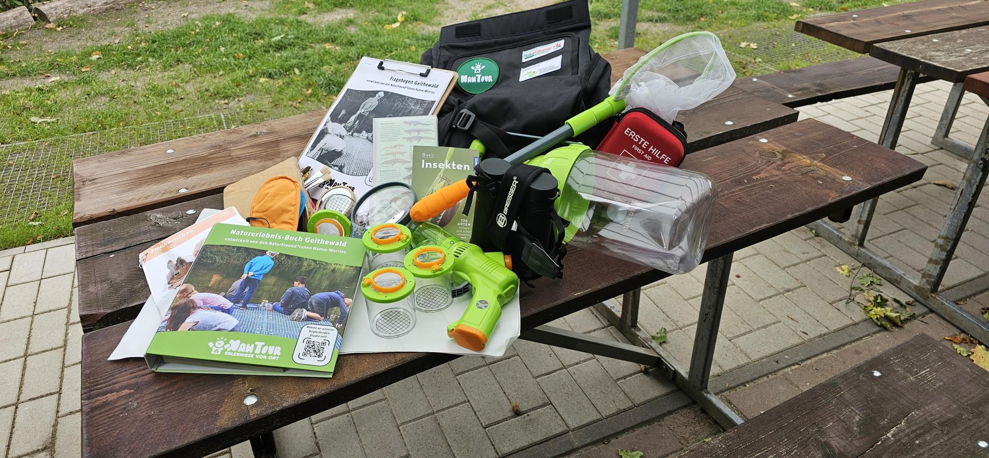 Die Rucksackmaterialien liegen ausgebreitet auf einem Tisch an der Naturschutzhütte.