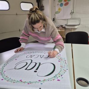 Marie gestaltet ein Flipchart-Papier für einen Workshop